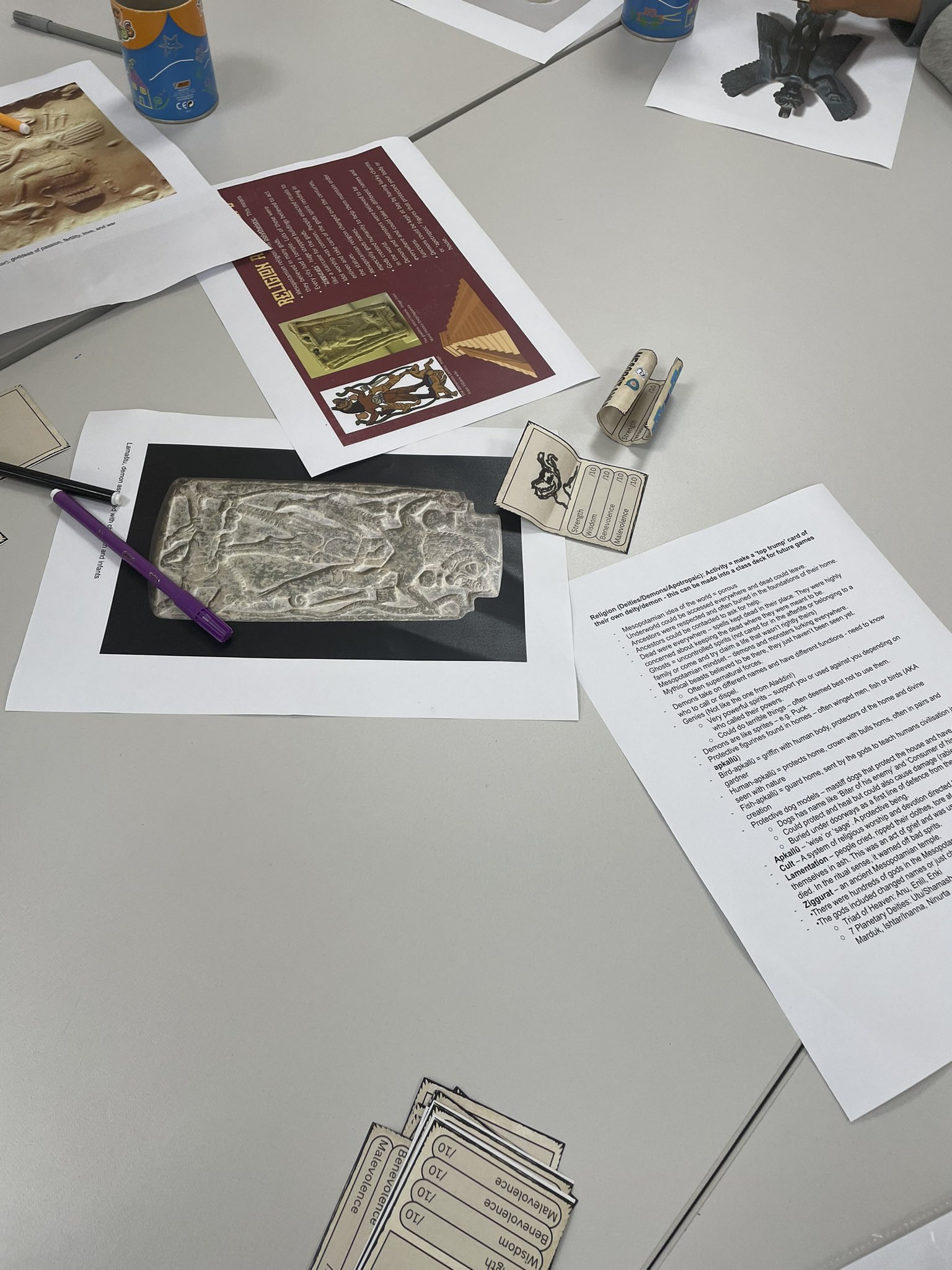 Examples of deities and information sheets on a table.